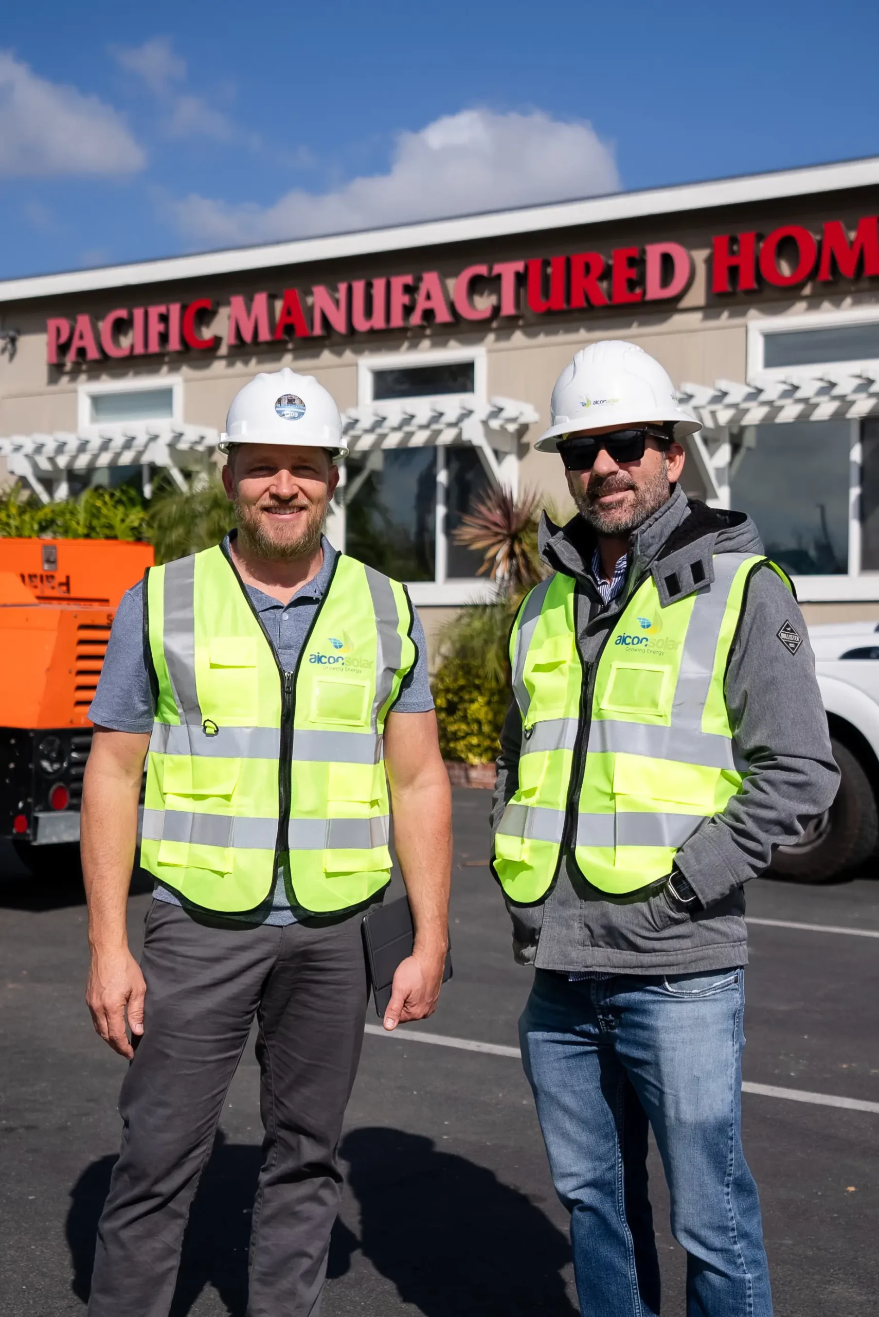 Two Aicon Solar workers posing in front of Pacific Manufactured Homes.