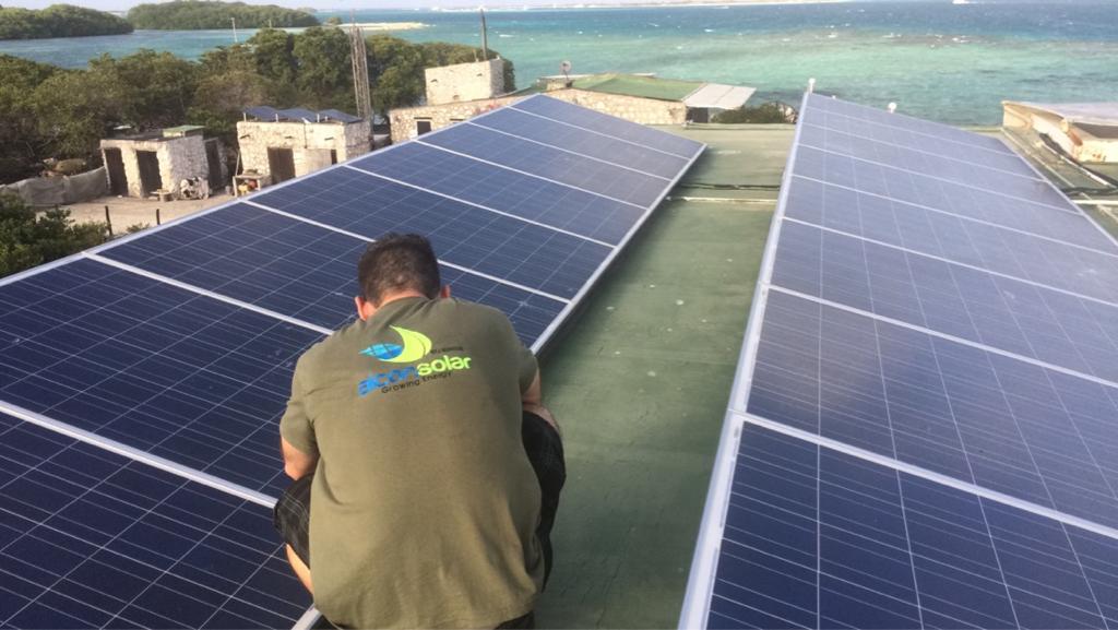 Aicon Solar installer working on rooftop solar near the ocean.