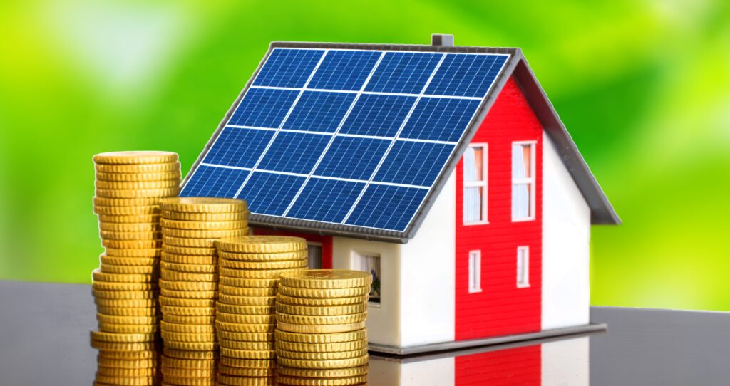 Miniature house with solar panels and stacked gold coins beside it.